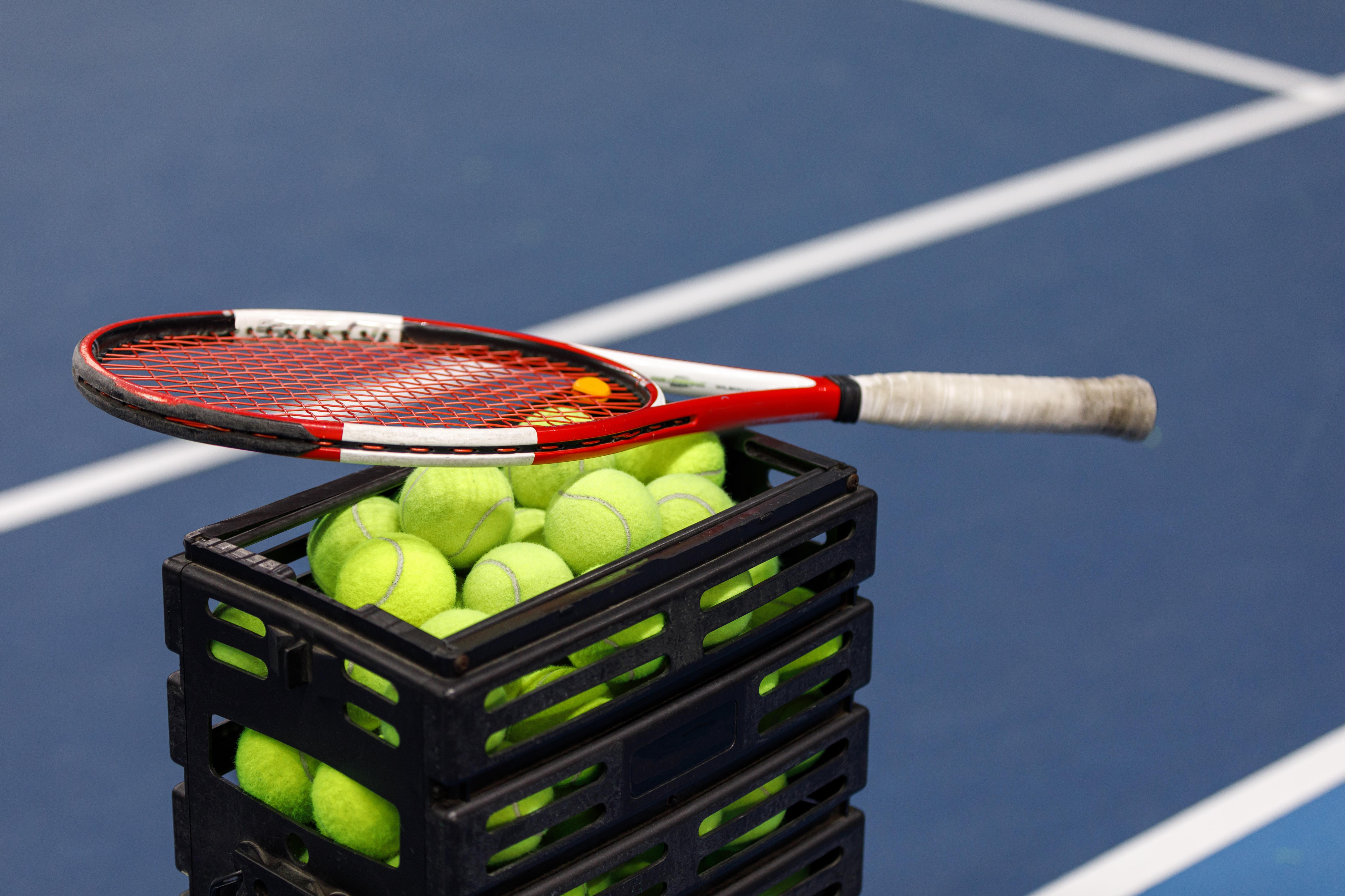 box-with-tennis-balls-tennis-racket-tennis-court